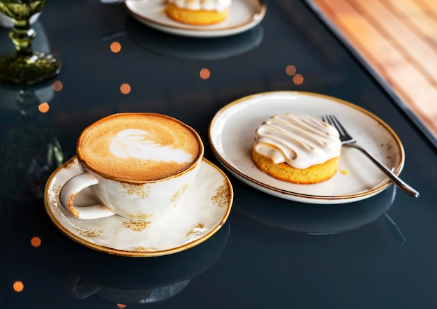 Mug with cappuccino or latte coffee vegan dessert cake on blue glass table background bokeh lights