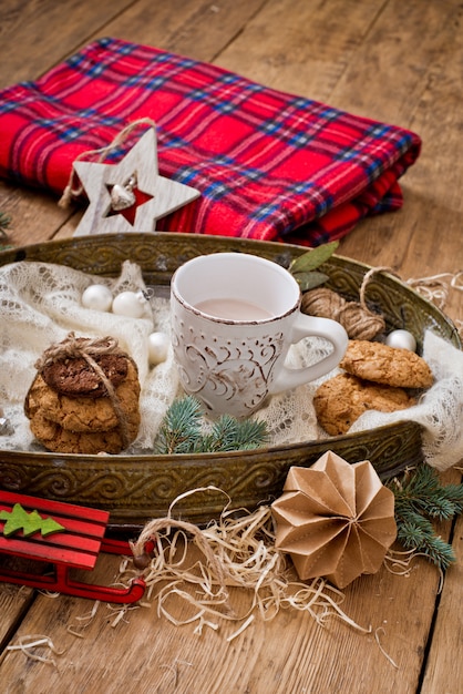 Mug with drink and cookies with Christmas decoration