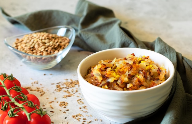 Mujadara lentils rice and fried onions on light background with gray textiles