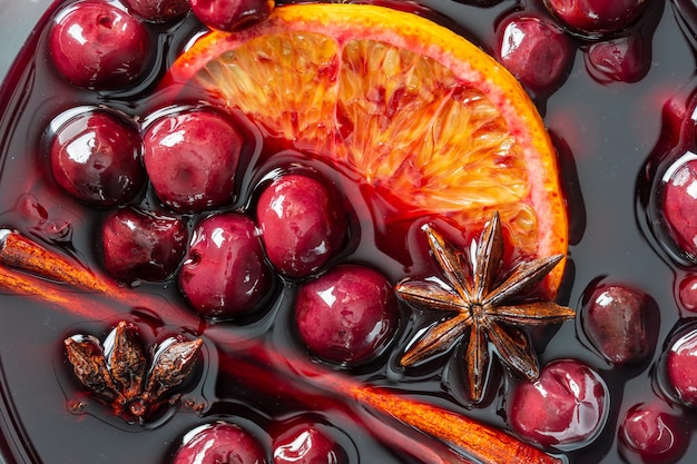 Mulled red cherry wine or punch with slice of orange and anise star and cinnamon Christmas beverage