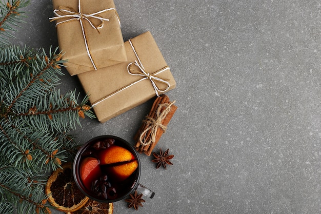 Mulled wine, a gift and spices on the table next to the tree 