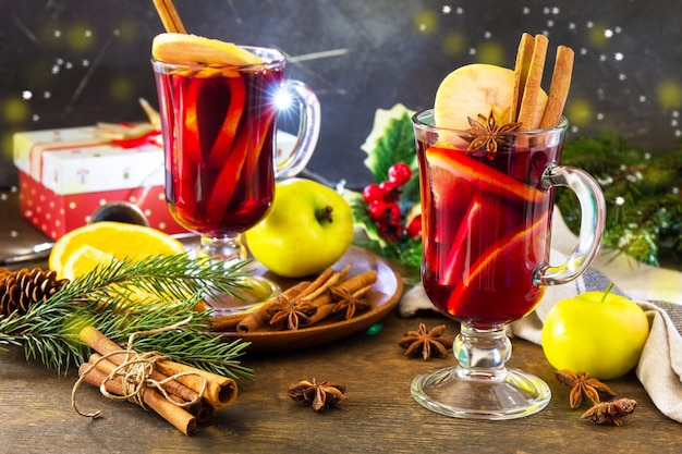 Mulled wine in glass mug with spices on rustic table Winter Christmas hot drink with orange apple