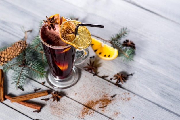 A mulled wine in glass on the white wooden background