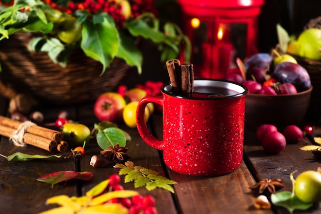 Mulled wine in a red mug on the autumn table