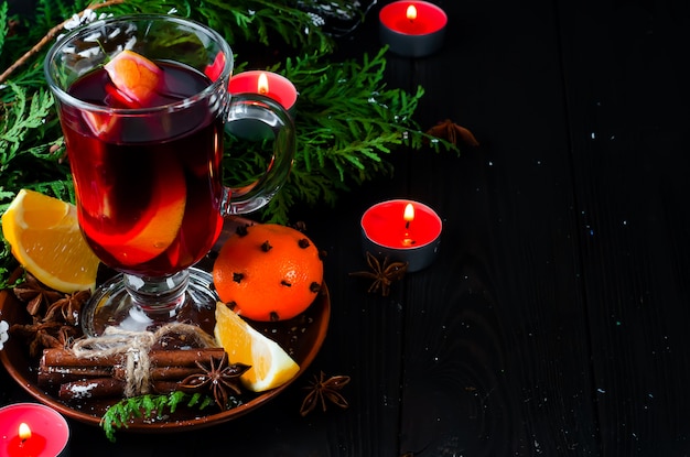 Mulled wine and spices on wooden background.