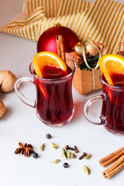 Mulled wine with orange slices, cinnamon sticks with Christmas balls
