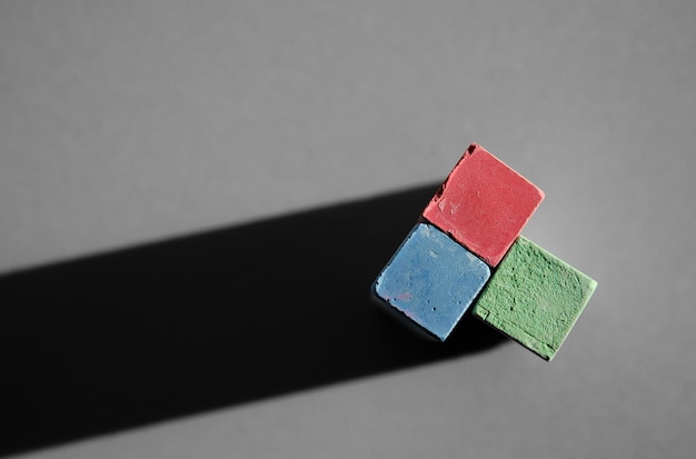 Multi-colored crayons for drawing close-up, on a gray background. Top view Poster for advertising chalk, preparation for school