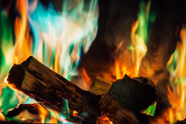 Multi-colored flame of fire burns in the fireplace