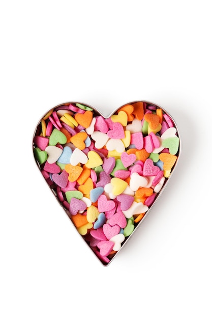 Multi-colored heart-shaped pastry topping in heart form on white background, minimalistic saint valentine`s day greeting card