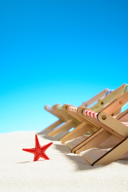 Multi-colored lounge chairs in a row and starfish