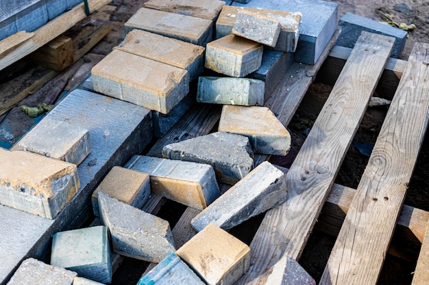 Multi-colored paving slabs. Pavement repairs and paving slabs laying on the roadway, with tile cubes in the background. Laying of paving slabs in the pedestrian zone of the city, improvement.