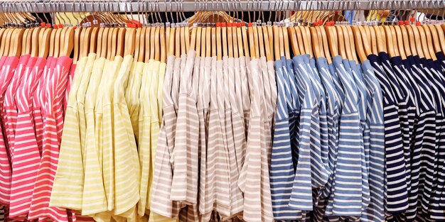 Multi-colored striped T-shirts on hangers in clothing store