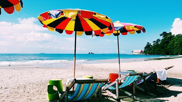 Multi colored umbrellas on beach against sky