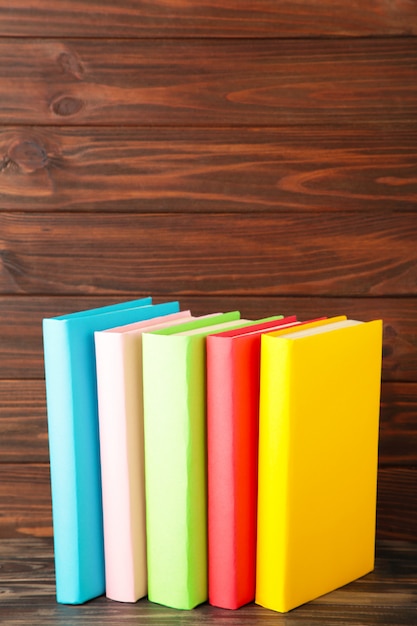 Multi coloured school books on a brown wood with copy space. Back to school