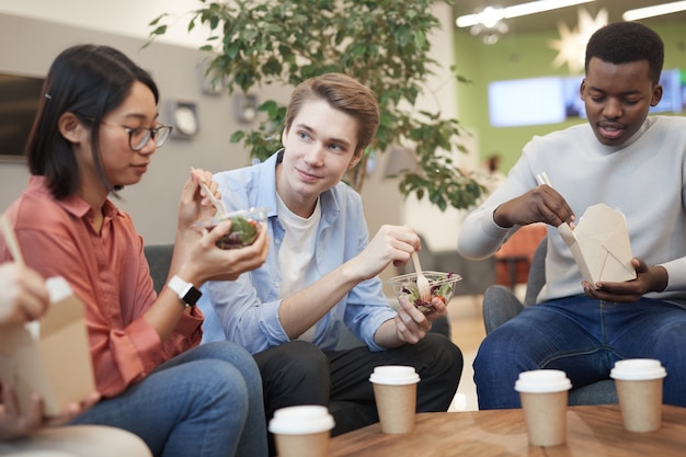 Multi-ethnic group of teenagers eating takeout food