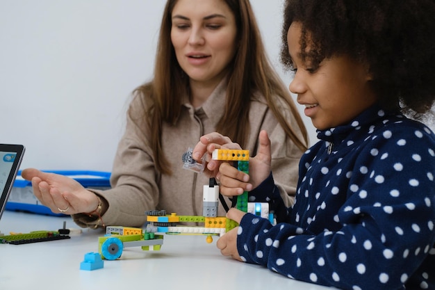 Multi ethnic kids at technology lesson constructing robot at school