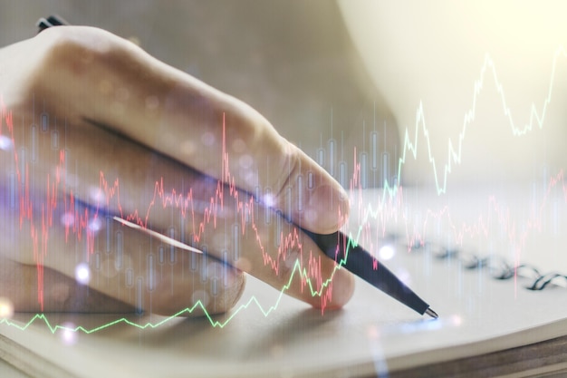 Multi exposure of abstract creative financial graph with hand writing in notepad on background forex and investment concept