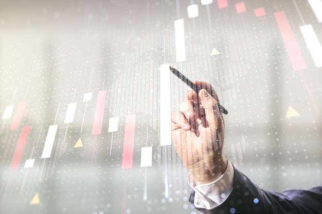 Multi exposure of analyst hand with pen working with virtual abstract financial graph and world map on blurred office background financial and trading concept