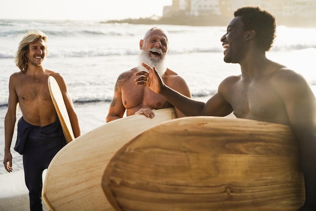 Multi generational surfer friends having fun on the beach after surf session  Focus on senior man face