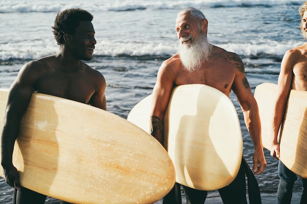 Multi generational surfer men having fun on the beach  Focus on senior man face