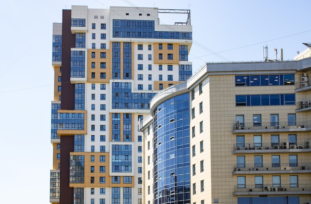 Multi-storey residential complex against the background of the sky. Multi-apartment residential buil. Apartments, offices, apartments in a multi-storey building in blue and brown