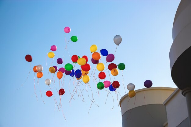 Photo multicolor balloons fly high clear blue sky near school.