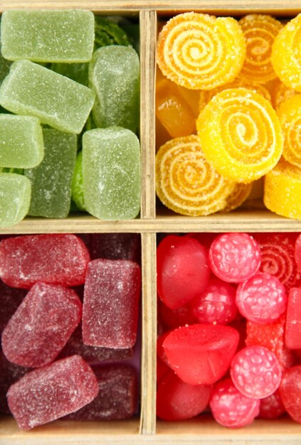 Multicolor candies in wooden box close up