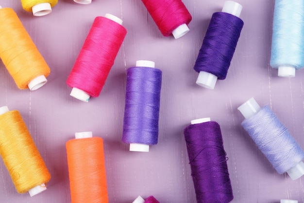 Multicolor sewing threads on wooden background