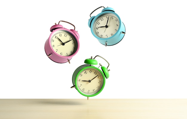 Multicolored alarm clocks flying over the table isolated on white background. Copy space