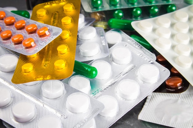 Multicolored blisters of tablets on a gray concrete background