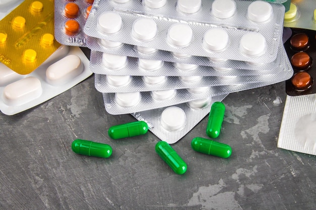 Multicolored blisters of tablets on a gray concrete background