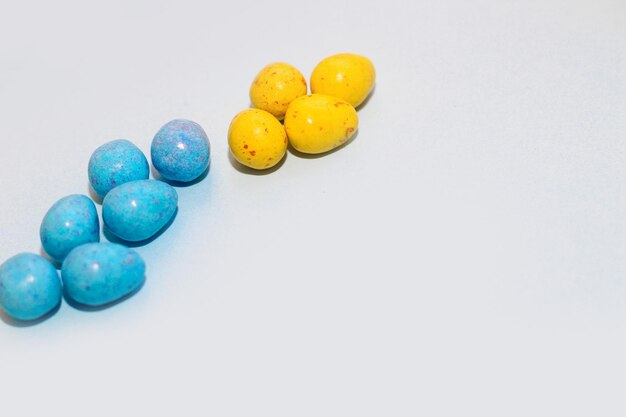 Multicolored blue and yellow chocolate easter candy eggs on paper background