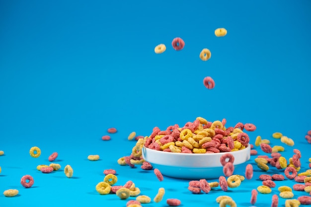 Multicolored breakfast cereal rings are poured into a plate