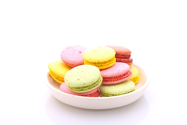 Multicolored cake macaroon in a white plate on a white background