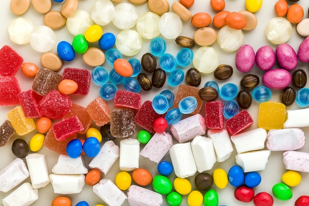 Multicolored caramel candies scattered on the table background. sugar products. colored sweets