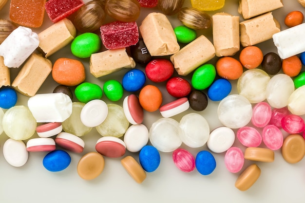 Multicolored caramel candies scattered on the table background. sugar products. colored sweets