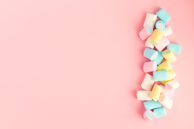 Multicolored colored vibrant marshmallows on a pink background the concept of childhood