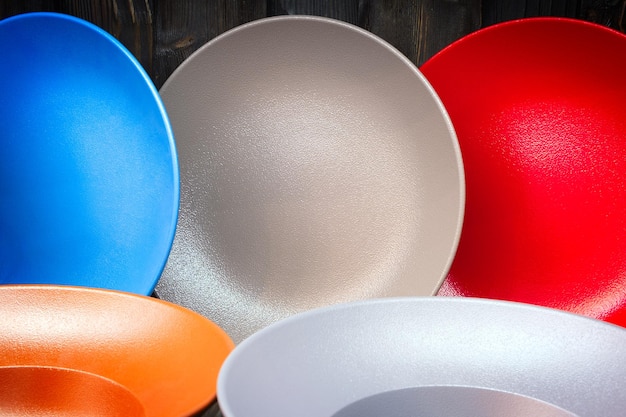 Multicolored dishes utensils on a wooden background