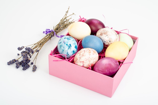 Multicolored eggs in open gift box. Concept of the Happy Easter holiday, greeting card template. Studio Photo