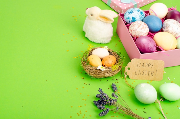 Multicolored eggs in open gift box. Concept of the Happy Easter holiday, greeting card template. Studio Photo