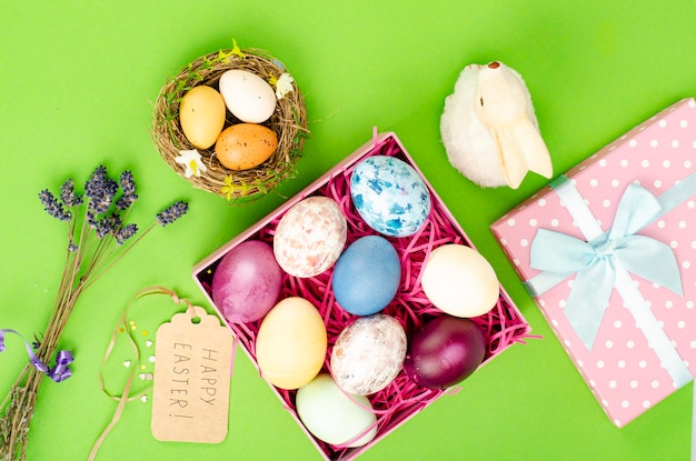 Multicolored eggs in open gift box. Concept of the Happy Easter holiday, greeting card template. Studio Photo