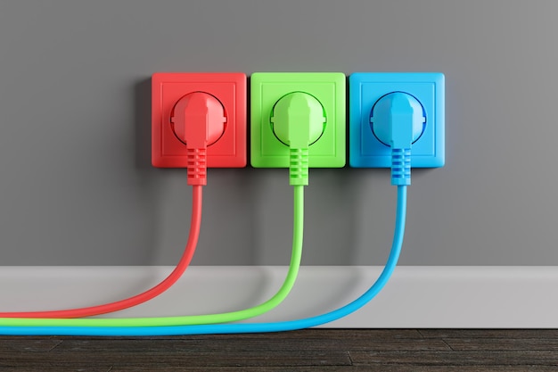 Multicolored electrical outlet on the wall in the room Three electrical plugs with a cable in the socket