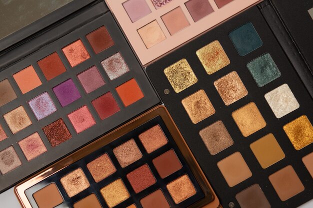 Multicolored eye shadow palettes of gold, pink, brown and bronze shades. Closeup shot