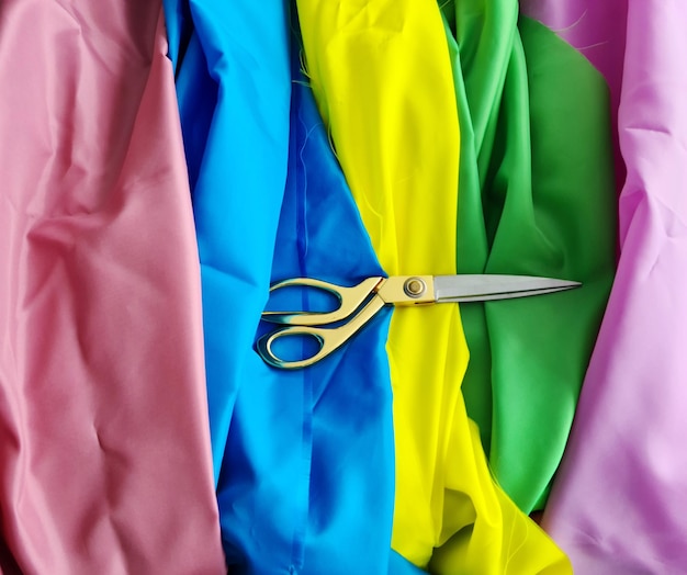 Multicolored fabric and scissors on table at seamstress