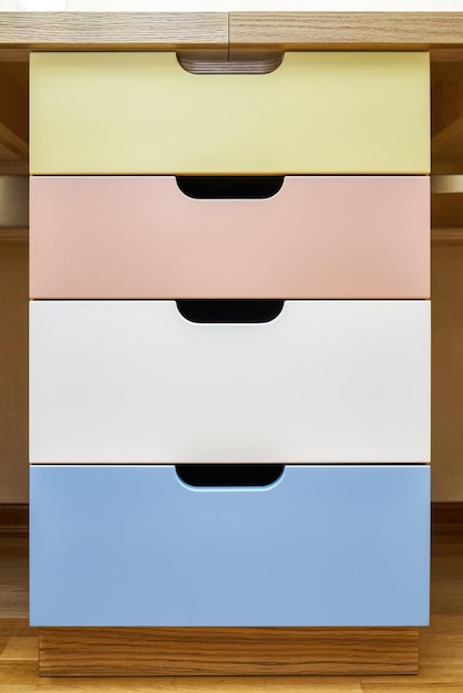 Multicolored finger pull facades of rollout drawers for stationery inside children table