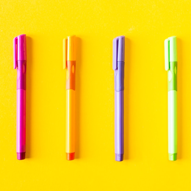 Multicolored four pen for writing on a yellow background