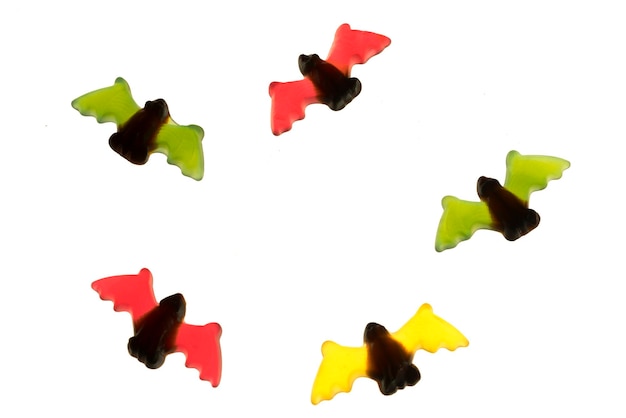 Multicolored gummy jelly bat candies over white background