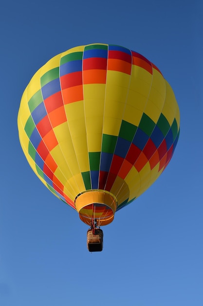 Multicolored hot air balloon close up in the blue sky