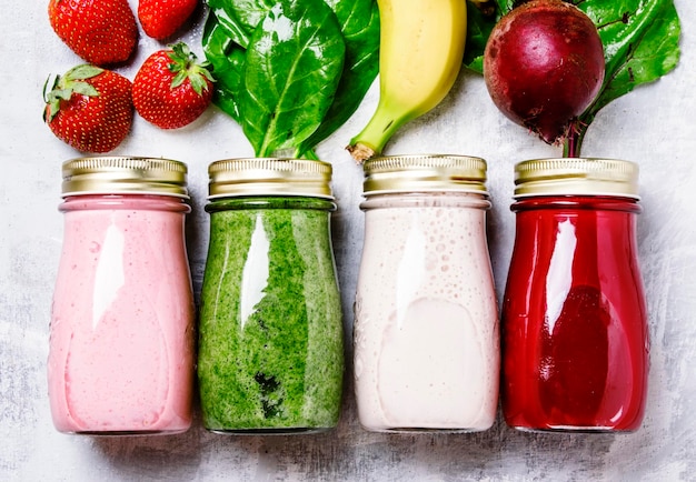 Multicolored juices and smoothies of fresh vegetables fruits and berries top view food background