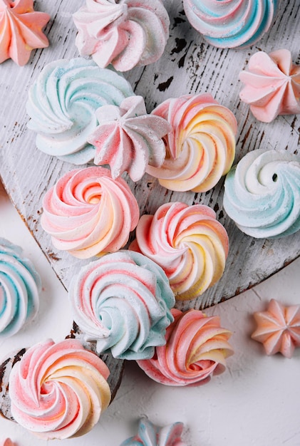 Multicolored meringue on wooden tray top view